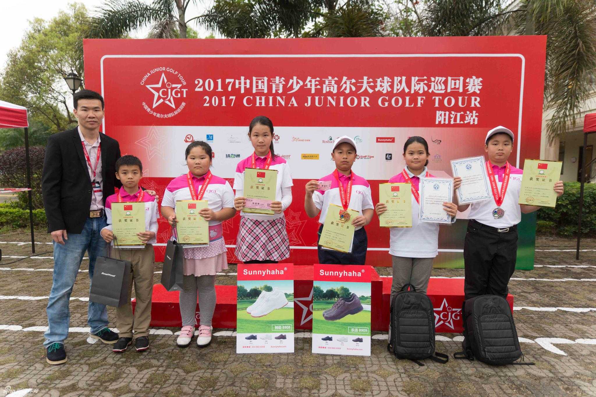 家长与孩子共同凝视着远处小选手的挥杆动作，眼神中充满了关切与期待。