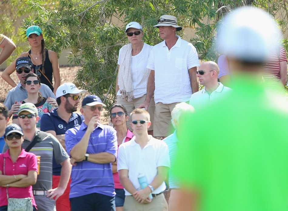 绿茵场畔凝眸处十指紧扣定情时 橄榄球赛看台上,金发佳人侧身凝望身旁的小麦,眼神温柔而专注,喧嚣赛场仿佛瞬间化为静谧背景。