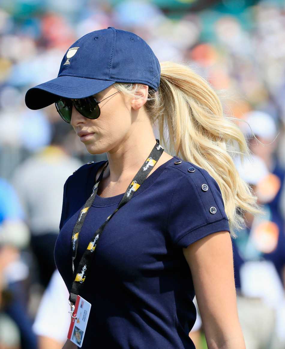 达斯汀·约翰逊与宝琳娜·格雷茨基在赛场边亲密交谈，宝琳娜笑容灿烂，展现模范情侣的默契瞬间。