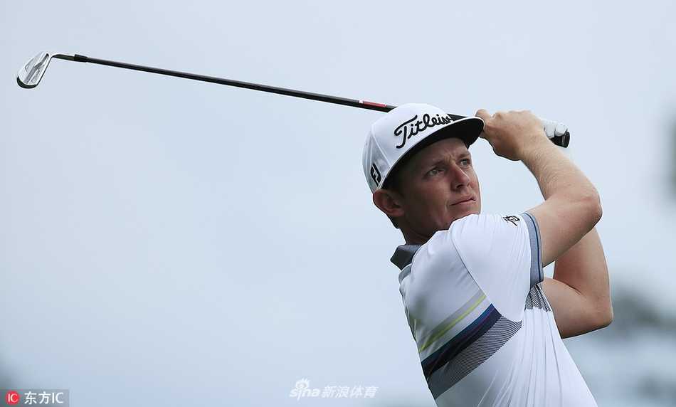 杰米·沃克尔在沙坑中练习救球，扬起的一片沙雾在逆光中如金粉闪烁