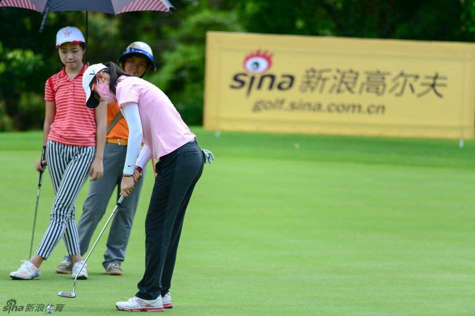 裁判员神情严肃而专注，正在果岭旁观察球位，确保比赛公平进行