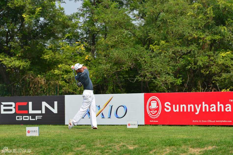 开球动作定格瞬间，球杆挥出有力弧线，高尔夫球飞向远方