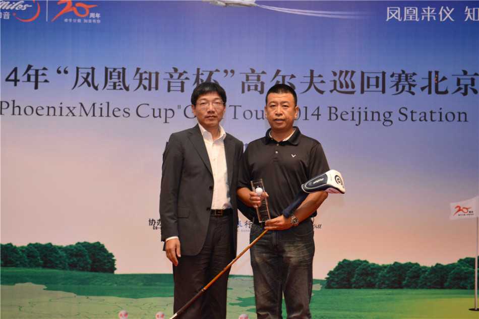 晚宴舞台上，一位男演员身着艳丽的女性服装进行反串表演，神态生动，台下观众看得津津有味。