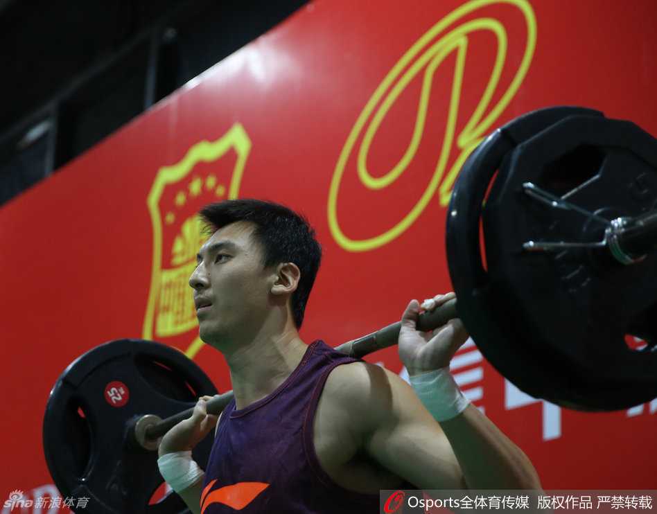 四川队老将孟达在卧推时脸部肌肉绷紧，脖子青筋显露，虽然表情用力但眼神依然保持着沉稳。