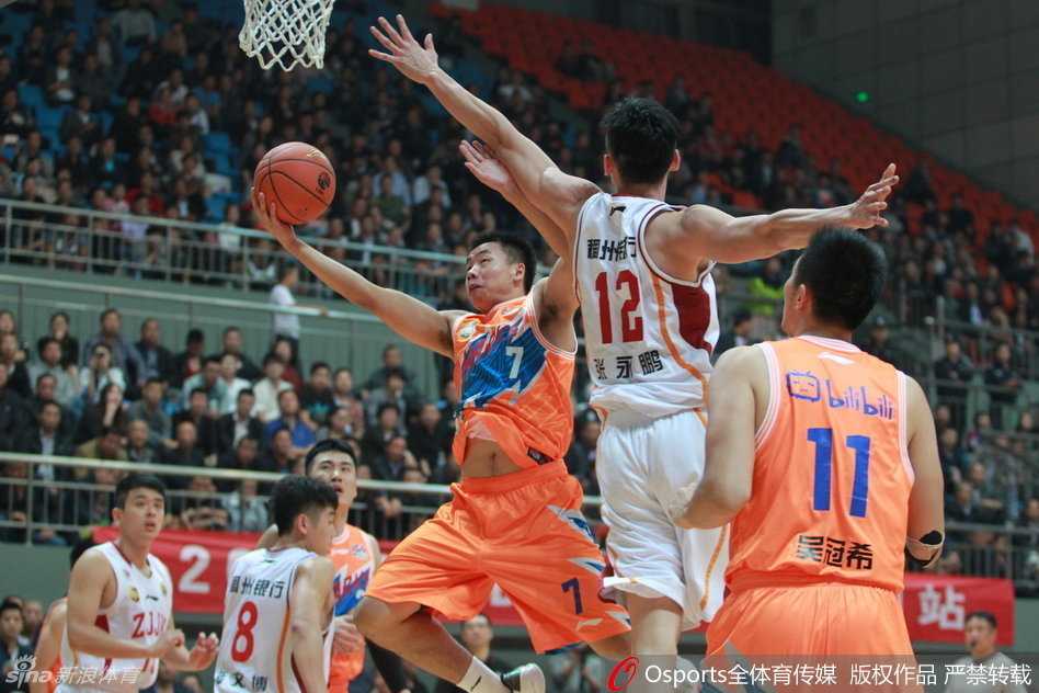 CBA铁血战场:封盖与绝杀交织的攻防大戏 广东队大外援布泽尔在吉林队的禁区内陷入重重包围,身边三名防守者形成合围之势,试图阻止这位NBA名将的进攻。