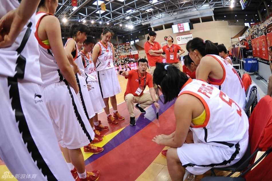 U17女篮世青赛中国小花绽放赛场不畏强手拼得第四名 暂停时刻,中国女篮的教练组组长李建新手持战术板,蹲在地上为队员们画着战术。球员们围成一圈,额头挂着汗珠,专注地聆听着教练的每一次布置,眼中充满对胜利的渴望。