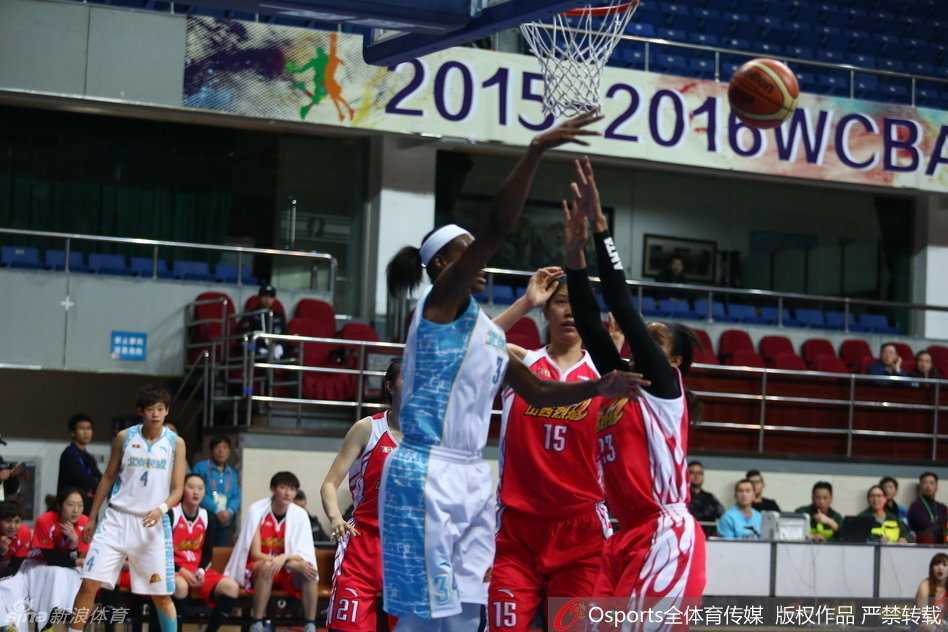 WCBA季后赛烽火连天:女篮豪强激战正酣,四强席位悬念迭起 防守球员奋力跃起封盖,指尖几乎触及篮球,空中防守态势紧张