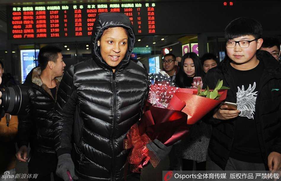 “不败女王”玛雅·摩尔王者归来,太原南站点燃山西球迷冬日激情 热情的山西女球迷手捧精美的鲜花,在人群中踮起脚尖,急切地将花束递到玛雅·摩尔面前,表达对她的喜爱。