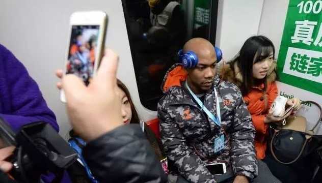 在偏远的山区小学里，他被一群可爱的孩子簇拥着，大家一起拿着书本开心地笑着