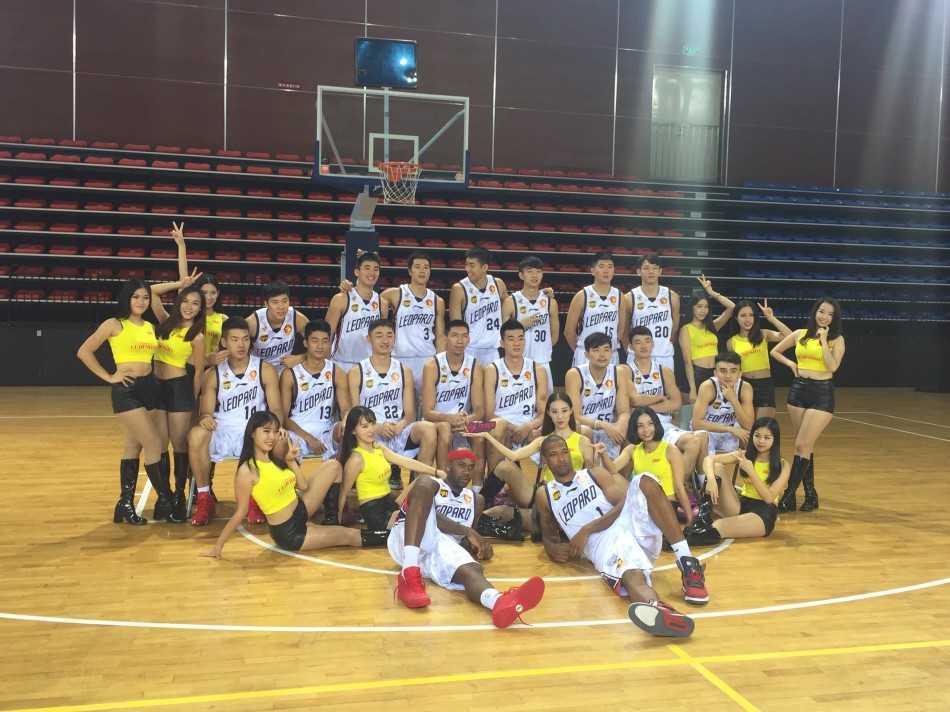 摄影师正在为深圳烈豹队拍摄新赛季定妆照，球员何忠勉在镜头前配合拍摄，摄影师则趴在地上寻找最佳角度，十分敬业。