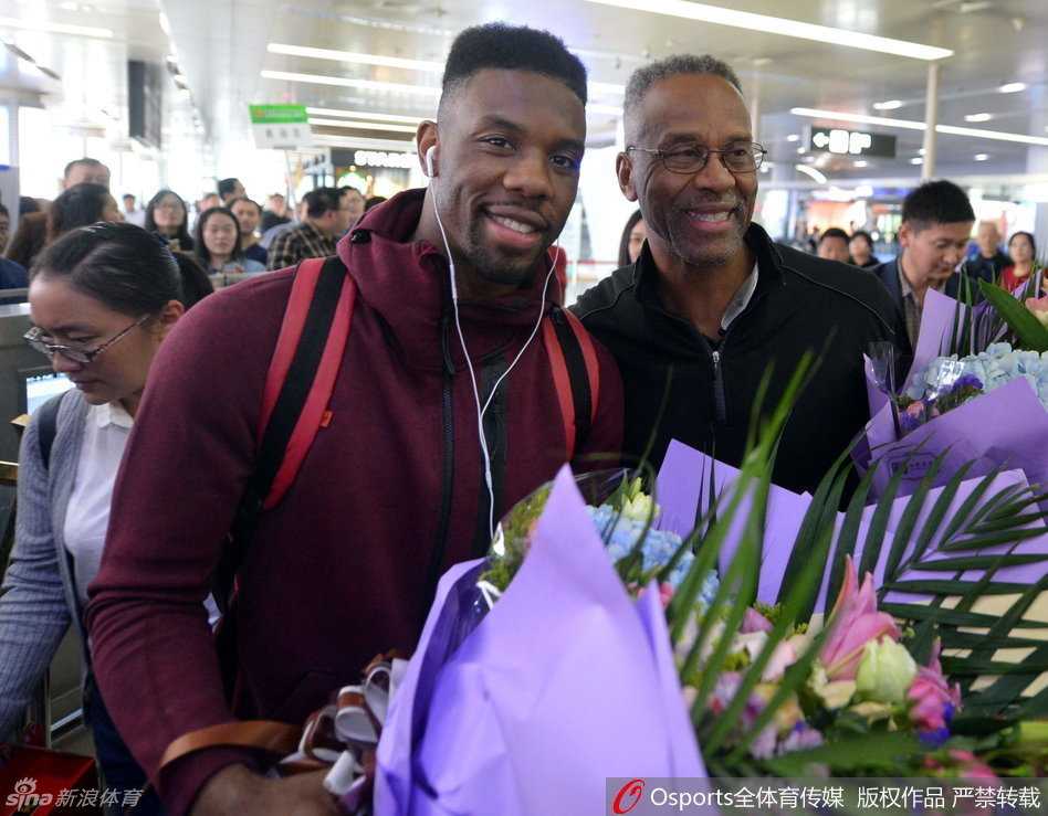 在一群热情的球迷中间，科尔被簇拥着，他亲切地揽着身旁球迷的肩膀，大家对着镜头共同露出开心的笑容。