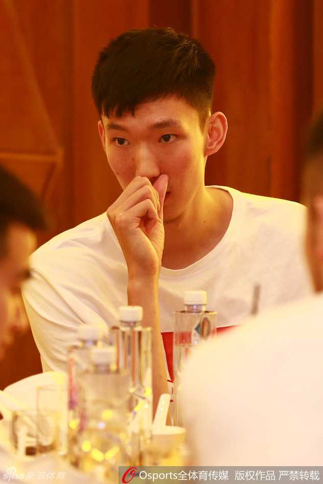 更衣室角落里，周琦和王哲林并肩而坐，两人低头看着手机屏幕，沉默中似乎还在回味着刚才的比赛，年轻的面庞上写满了不甘。