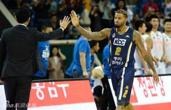 对方控卫面对防守沉着冷静，他一边娴熟地运球，一边伸出三根手指向队友示意战术，眼神中闪烁着指挥官的智慧光芒。