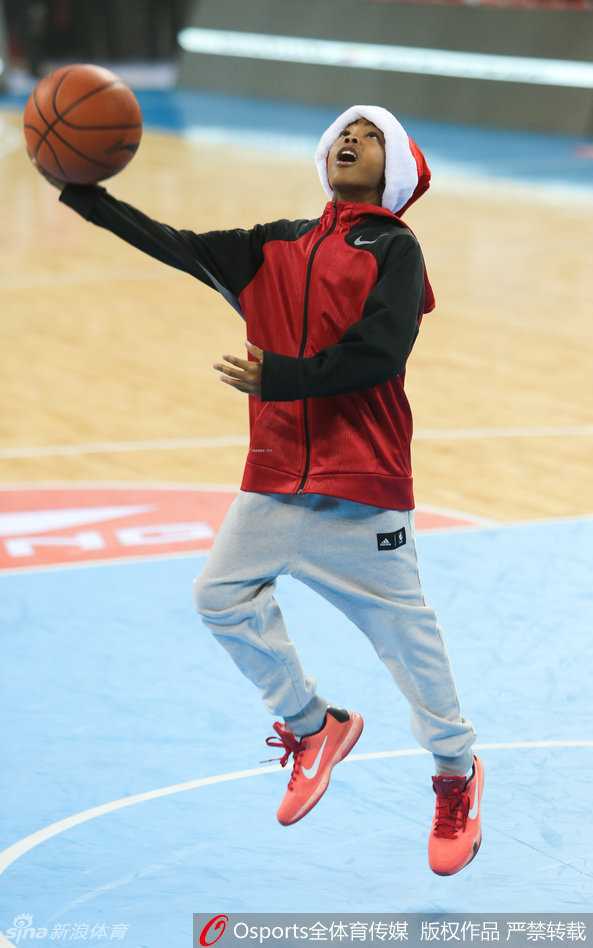 小马布里在空荡的球场看台前练习运球，他身着休闲卫衣，低头专注地控制着篮球，步伐灵动，举手投足间流露出与其年龄不符的成熟篮球技艺。