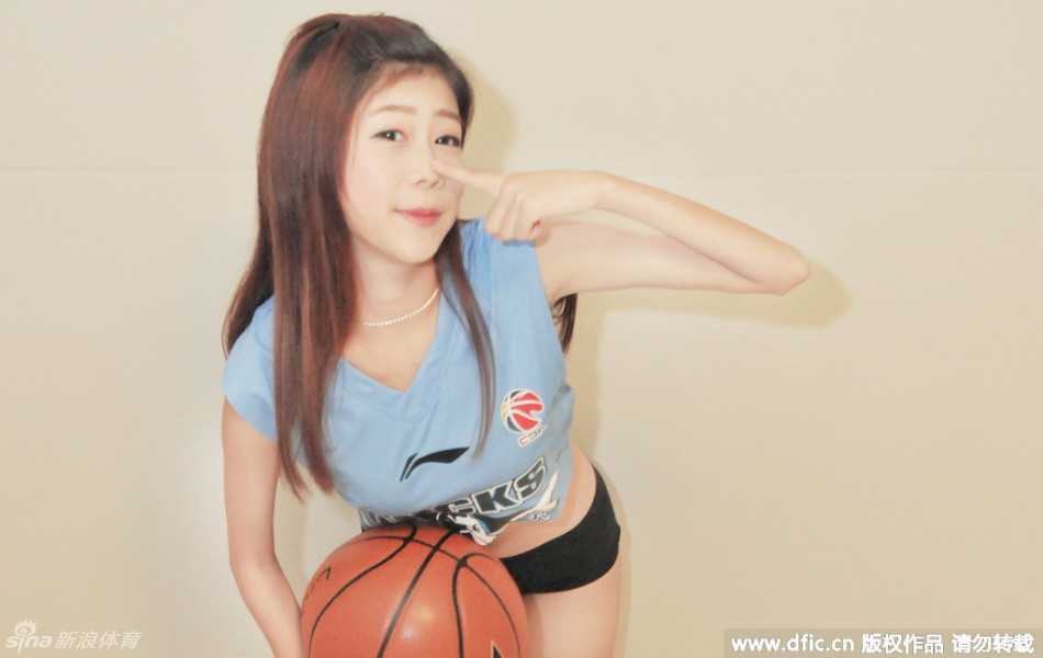 篮球宝贝展露甜美笑容，她身后的五棵松体育馆仿佛即将被战火点燃，青春的力量与竞技体育的激情在这一刻完美交融。