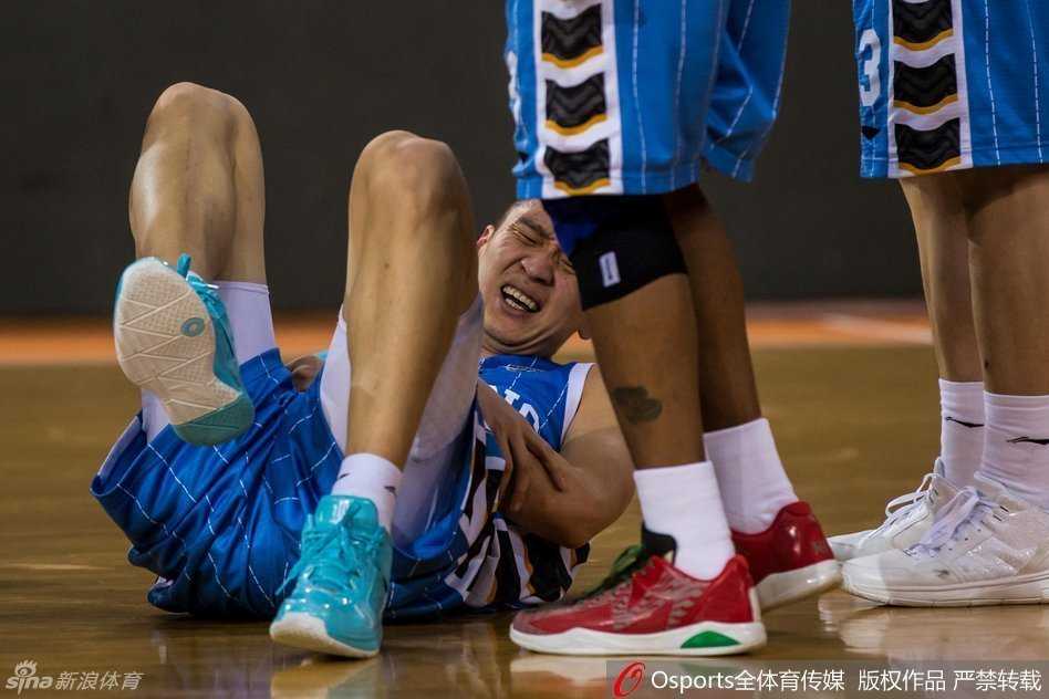 孙悦受伤后返回更衣室，队医用冰袋为他冰敷肿胀的左肘，他神情落寞地望向远处，心中充满对伤势的担忧。