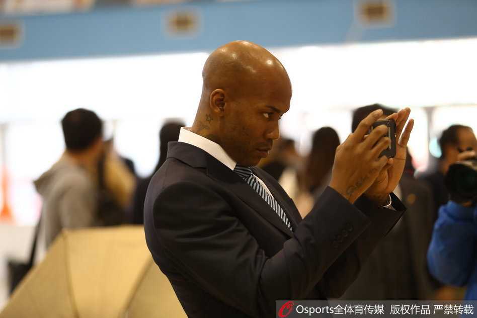 京城男模队集结!镜头定格北京首钢冠军的骄傲与温情 马布里单膝跪地,双手将篮球递给身前的方硕,方硕俯身接球,两人神情专注,仿佛在进行一场神圣的火炬交接仪式。