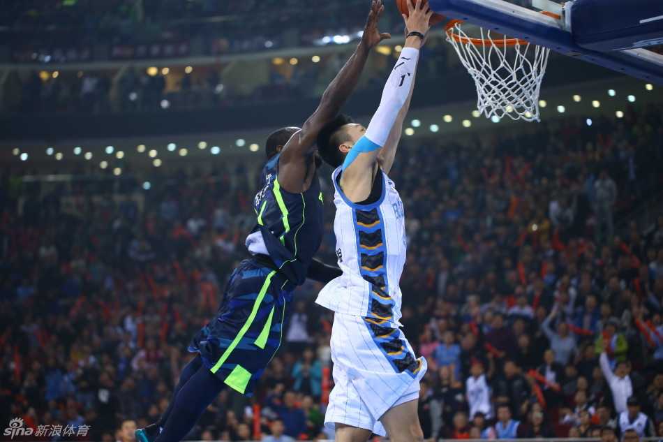 易建联在多名北京队球员的包夹防守下，依然艰难地起身上篮，表情坚毅，肌肉线条分明，展现出他作为球队核心极强的杀伤力与不屈的斗志。