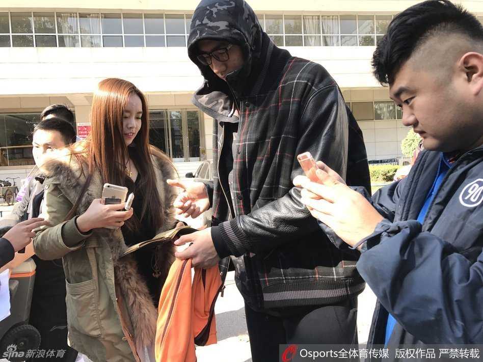 八一队训练结束后，王治郅被几位美女粉丝拉住合影，身高出众的他贴心配合，画面温馨有趣，记录下赛场外的轻松时刻。