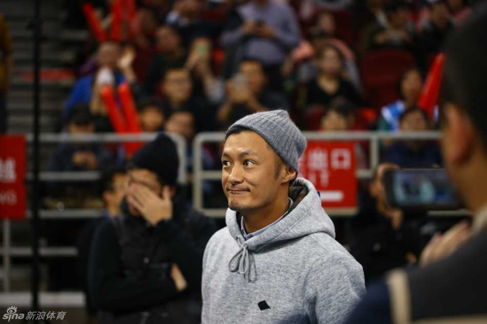 余文乐现身五棵松体育馆，身穿简约休闲装，目光专注地望向赛场，神情中透露出对即将开始的京粤大战的期待。