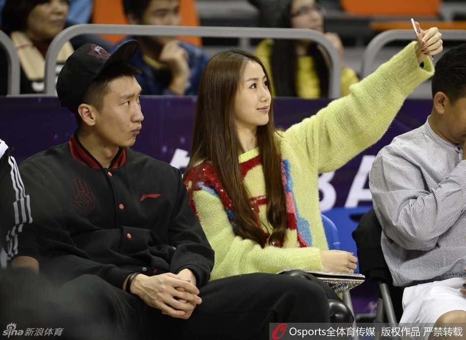 孙悦与陈露在座位上甜蜜互动，孙悦眼神温柔地看向妻子，似乎在说着只有两人才能听见的情话，而陈露则手拿时尚手包，面带微笑静静聆听，画面温馨自然。