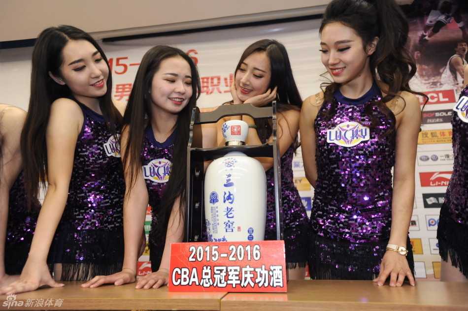 庆功酒的细节特写，瓶口系着的大红花绸带映衬着酒瓶上的金字，空气中似乎已弥漫起胜利的醇香。