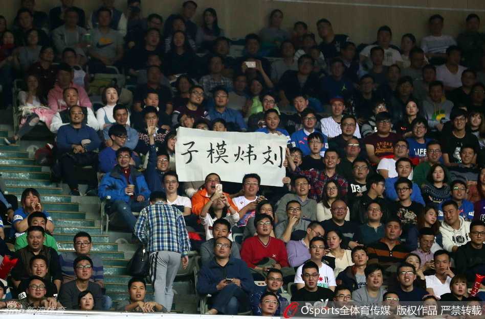 上海大鲨鱼的队员们在获胜后围成一圈，激情庆祝，汗水在灯光下闪闪发光，他们身后的记分牌上显示着最终的胜利比分。