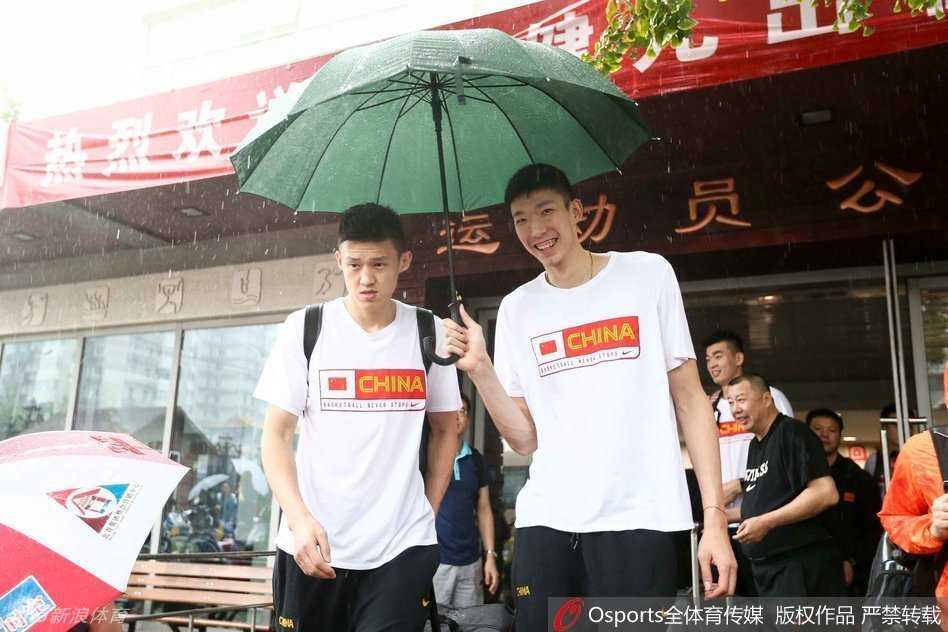 主帅宫鲁鸣在领队的撑伞护送下准备上车，这位功勋教头神情严肃，他将带领这支年轻的队伍去感受世界最高水平的篮球对抗。