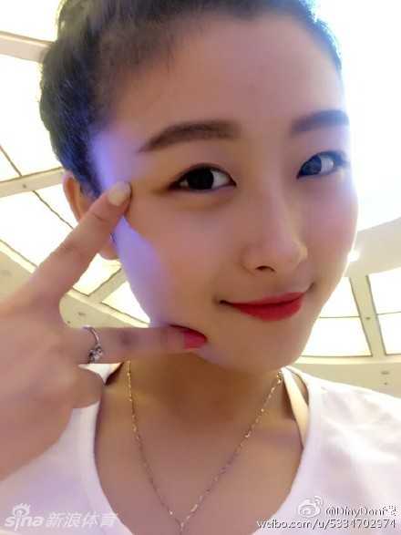 阳光下的黄思莹，身披柔顺长发，身着白色露肩装，对着镜头露出治愈系的甜美微笑，背景的绿植都显得生机勃勃