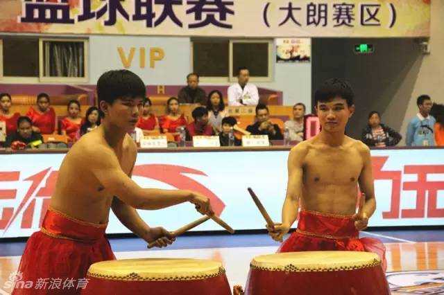 两位身着红衣的听障少年目光坚毅，他们用力挥动鼓槌，敲响面前的大堂鼓，鼓槌落下的瞬间仿佛有千钧之力。