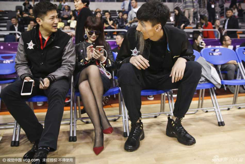 周琦在场上露出腼腆笑容，浓密的假眉毛与长胡子让他的笑脸显得格外憨厚可爱，与场上紧张激烈的比赛氛围形成有趣对比。