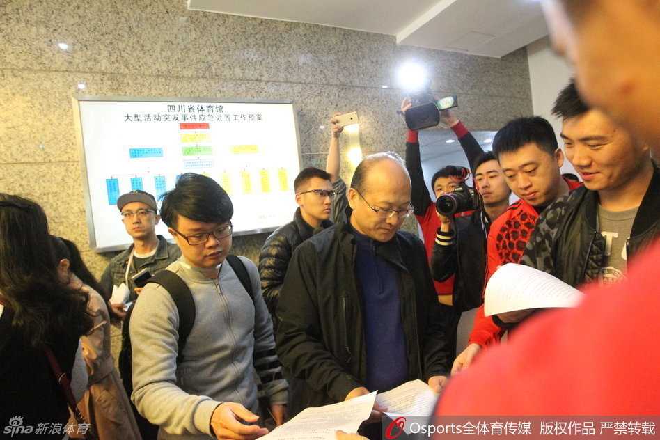 张雄在会议间隙接受采访，身后背景是总决赛的备战氛围，他的表情透露出处理此次棘手事件的复杂心情。