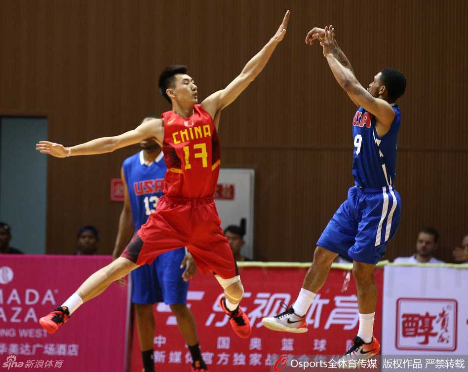 中国国奥男篮的队员们肩并肩坐在场边，目光紧紧跟随着场上局势，神情专注，随时准备为队友加油助威。