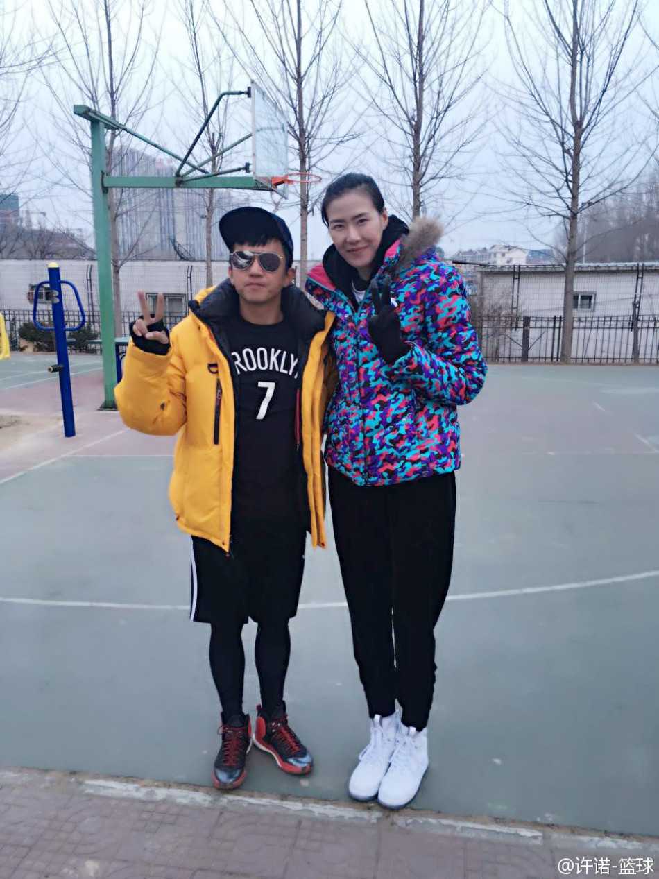 女篮颜值担当许诺约战邓超俞白眉 球场秒变粉丝见面会 许诺与著名编剧俞白眉在场上愉快合影,两人笑容灿烂,身后是喧闹的球场,展现了体育竞技之外的轻松与友谊。