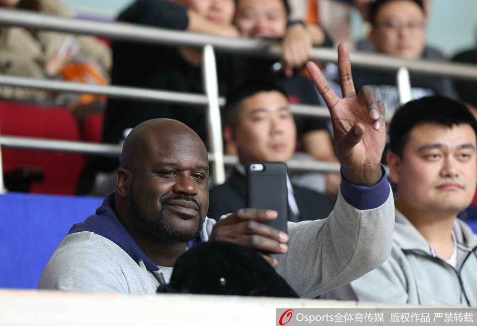 奥尼尔坐在姚明身旁，搞怪地对着镜头比出‘二’的手势，身边的姚明则是一脸宠溺的微笑，两大巨人同框的画面让场边瞬间变成了欢乐的海洋。