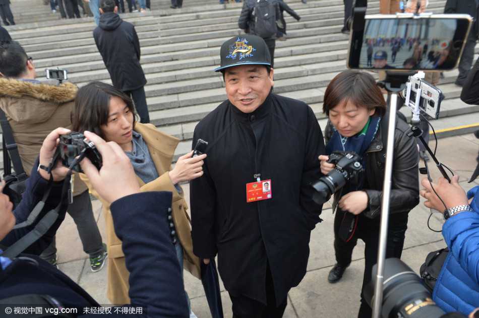 姜昆两会行:头顶冠军荣耀,心怀国学未来 春日的阳光洒在人民大会堂台阶上,姜昆面带标志性的微笑,头顶蓝色北京冠军帽信步走来,眼神中透出履职的从容与自信。