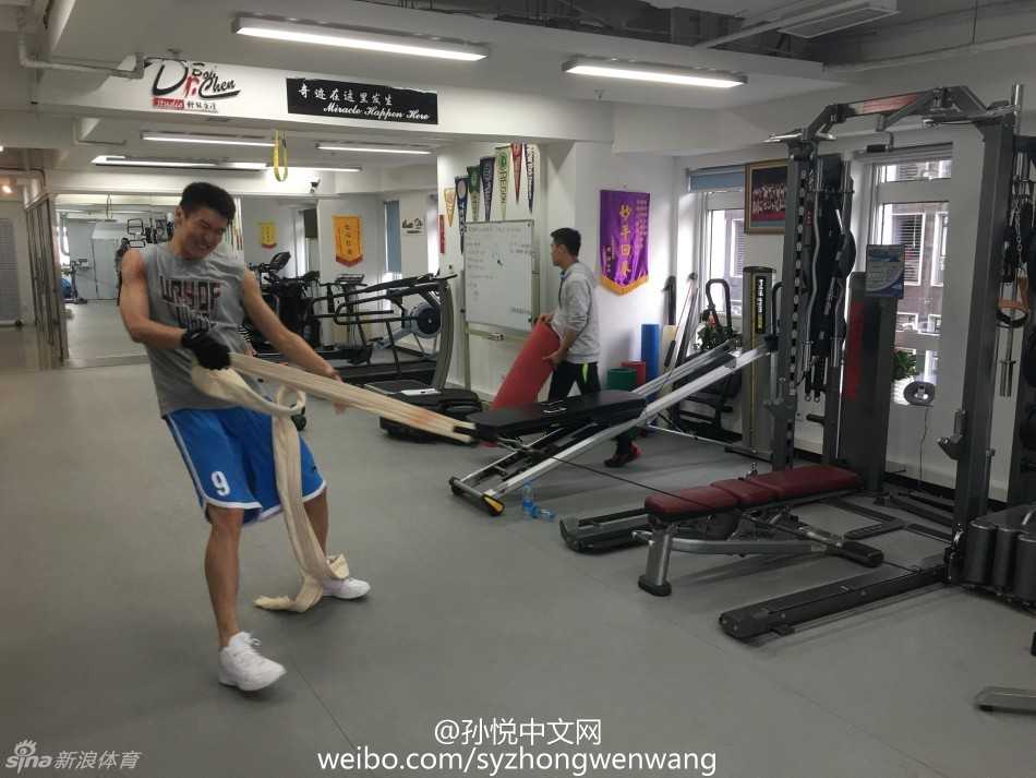 训练师正在仔细查看孙悦腿部肌肉的发力情况，孙悦紧咬牙关，额头渗出细密的汗珠，每一下抬腿都充满了力量感与挣扎，仿佛在与地心引力进行无声的抗争。