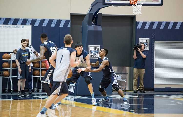 周琦在训练师的协助下进行核心力量训练，汗水湿透了衣背，每一滴汗水都见证着他为冲击NBA所付出的努力。