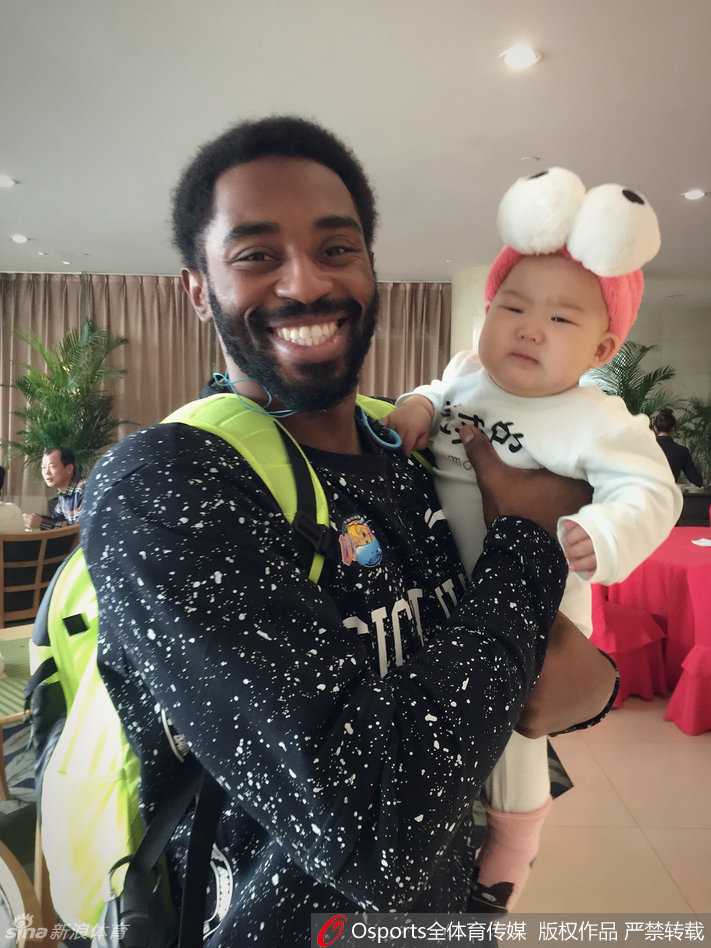 孟达爱女探营记:哈达迪铁汉柔情抱娃,小公主萌态可掬成球队宠儿 小公主被一位戴着眼镜的叔叔抱着,她显得十分乖巧,不哭不闹。身后的孟达和队友们看着这温馨的一幕,脸上都洋溢着轻松愉快的笑容,整个画面充满了大家庭般的融洽与暖意。