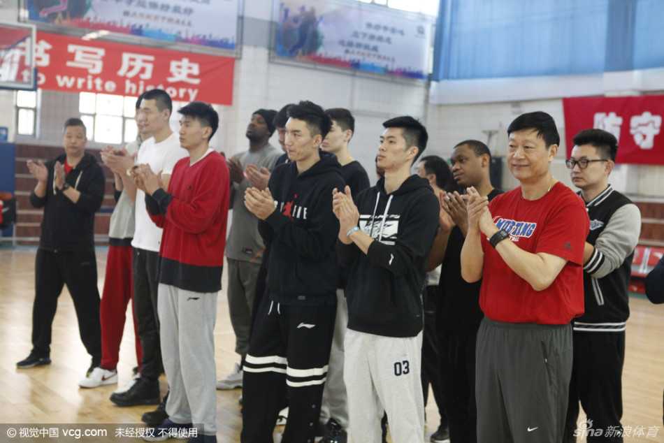 寒冬里的暖流:忆二零一六年春城慰问新疆男女篮将士 新疆广汇男篮的球员们整齐列队,穿着标志性的蓝色训练服,李秋平指导站在队伍前方,队员们神情专注而坚毅,掌声在空旷的训练馆中回荡