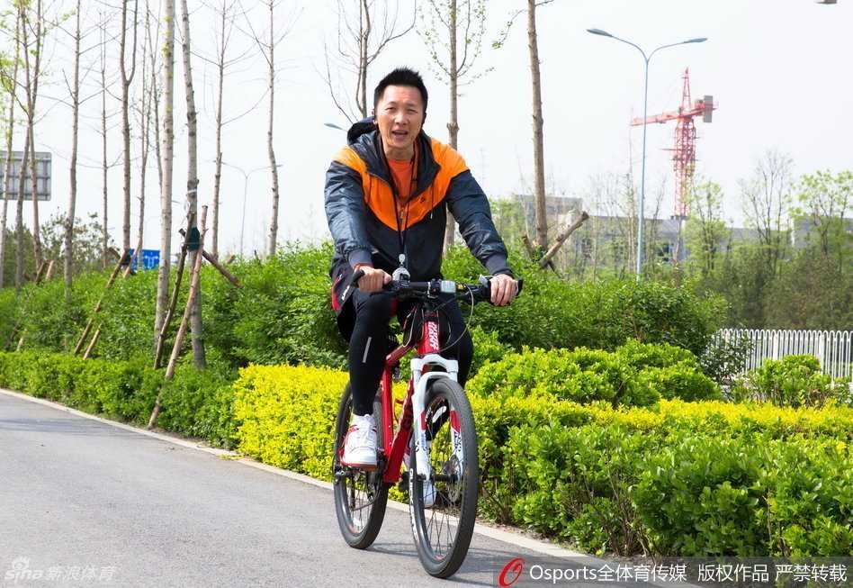 主教练许晋哲在场边双手抱胸，目光如炬地注视着场内队员们的每一次跑动和投篮，神情专注而严肃。