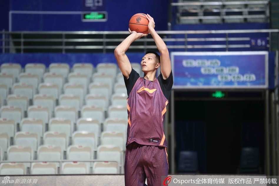 董瀚麟在内线双手持球，眼神余光扫视着队友的跑动路线，准备将球巧妙地传给切入篮下的易建联，完成一次精彩的配合。