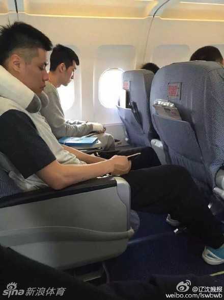 休息室内，贺天举无力地垂下受伤的右手，手腕处包裹着厚厚的医疗绷带，表情落寞而痛苦，身旁的队友低头看着手机，仿佛想从纷乱的信息中寻找一丝平静。