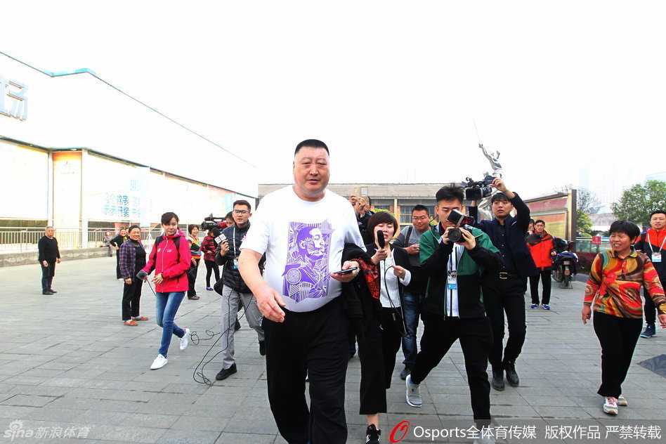 四川队主教练杨学增在新闻发布会后被人群层层包围，话筒和镜头几乎要将他淹没，他的眼神中透露出一种与平常比赛不同的凝重与无奈。