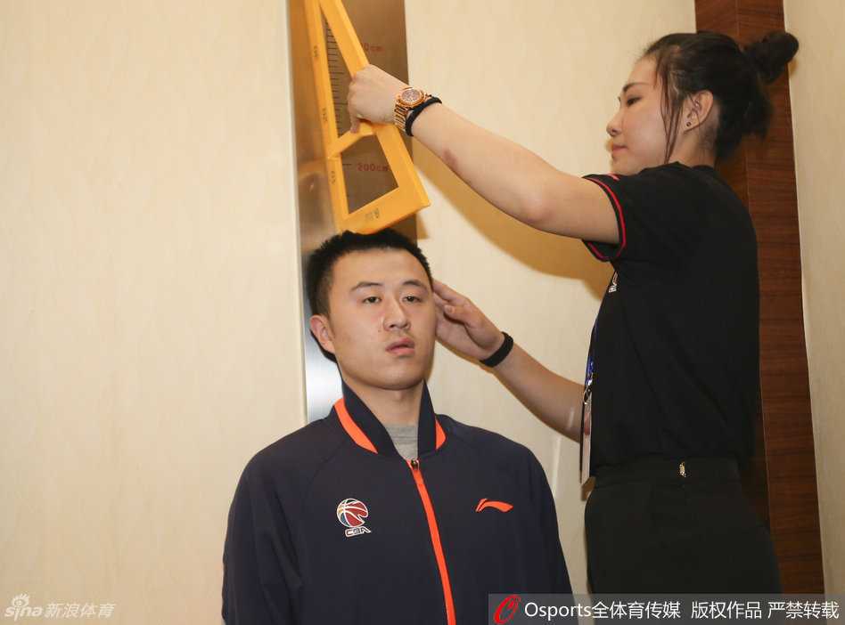 刘晓宇正准备进行身高测量，他脱掉鞋子站上仪器，一双长腿在人群中格外显眼，尽显控卫的身体天赋。