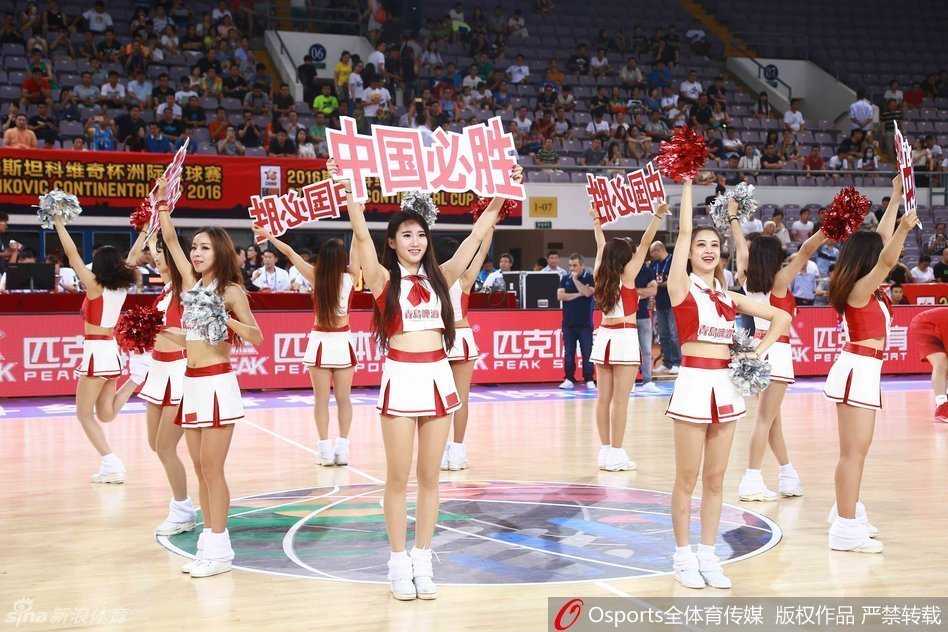 篮球宝贝们身着红白配色劲装，马尾辫随着动感的舞步在空中划出活力弧线，她们面对看台绽放灿烂笑容，用充满节奏感的挥手动作瞬间点燃全场热情。