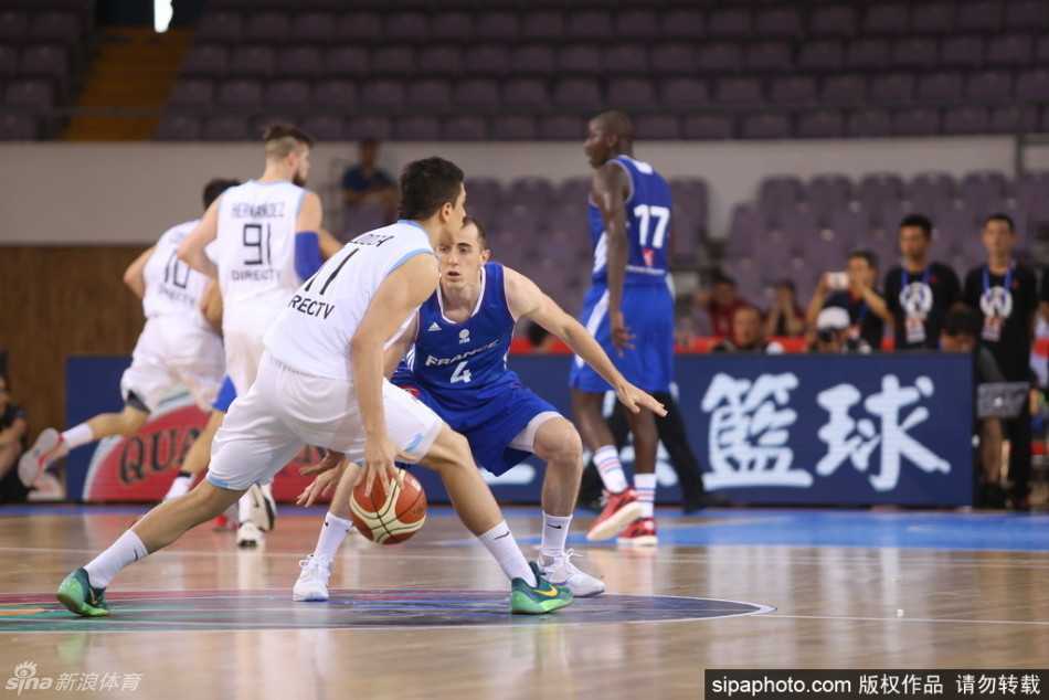 阿根廷队员试图在三分线外进行尝试抢断，他飞身扑向法国队的传球路线，指尖几乎碰到了皮球，防守极为拼命。