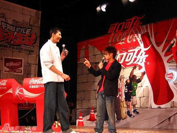 《街头篮球》游戏画面中，一名嘻哈风格的球员高高跃起准备灌篮，背景是喧闹的街头球场，充满了热血与青春的气息。