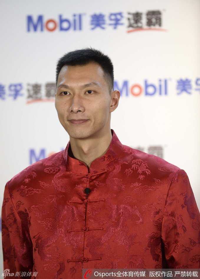 易建联身穿深色唐装接受采访，目光炯炯有神，嘴角带着淡淡笑意，尽显核心球员的霸气与从容