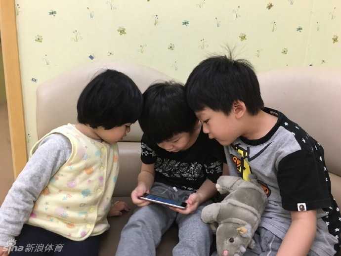 朱芳雨和两个儿子紧紧靠在一起面对镜头，父子三人眉眼间满是笑意，画面温馨极了。